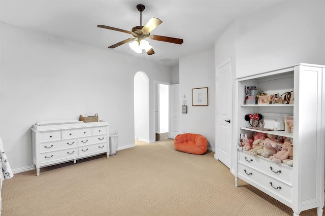 game room featuring a ceiling fan, baseboards, arched walkways, and carpet flooring