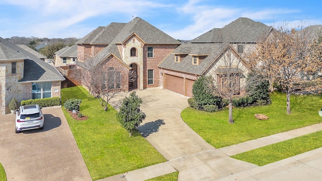 french country style house with driveway, brick siding, a front yard, and stone siding