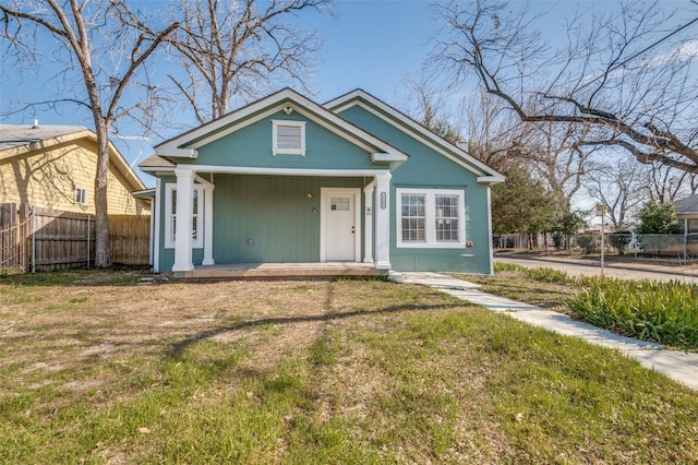 view of front of house featuring a porch, fence, and a front lawn