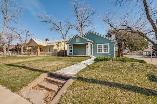 view of front of property featuring fence, a chimney, and a front lawn