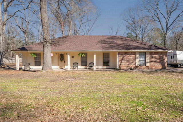 view of front of home with a porch, brick siding, and a front lawn