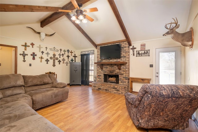 living room with light wood-style floors, a brick fireplace, plenty of natural light, and lofted ceiling with beams