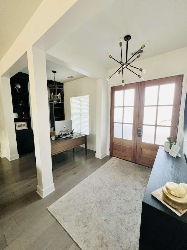 interior space with a chandelier, french doors, and baseboards