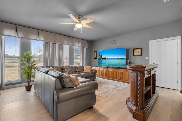 living area with a ceiling fan and light wood-style flooring