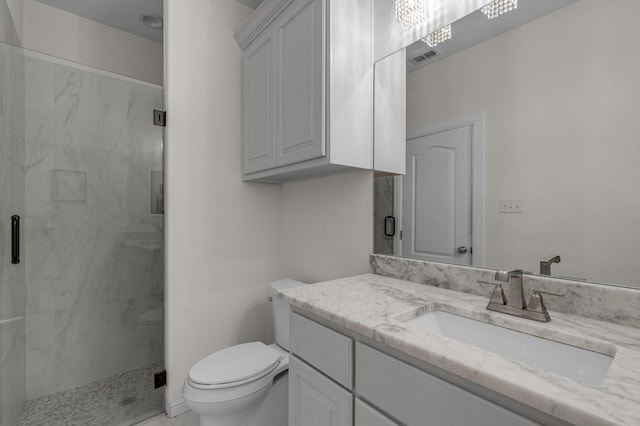 bathroom with toilet, a marble finish shower, and vanity