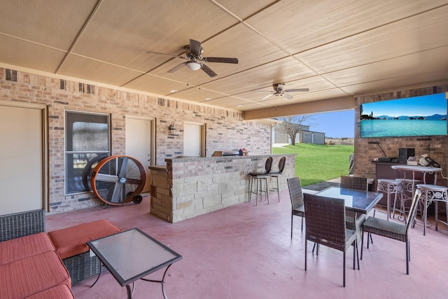 view of patio / terrace with outdoor dining area, ceiling fan, and exterior bar