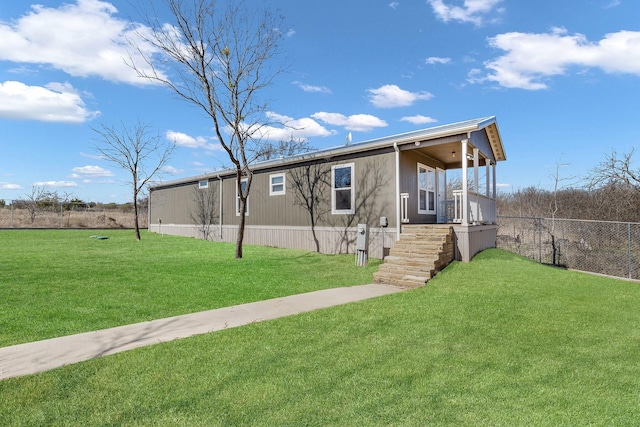 manufactured / mobile home featuring covered porch, a front yard, and fence