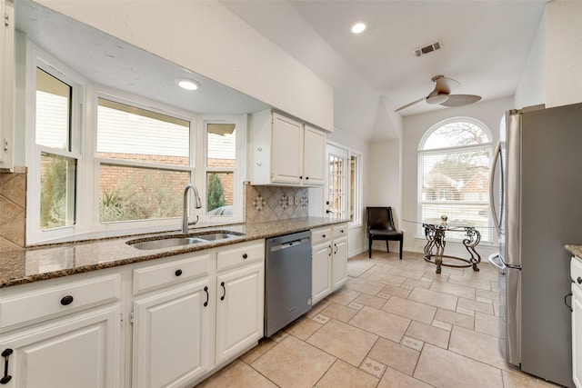 9005 Cumberland Dr, Irving, TX 75063 - kitchen with stainless steel appliances, a sink, decorative backsplash, stone counters, and white cabinetry
