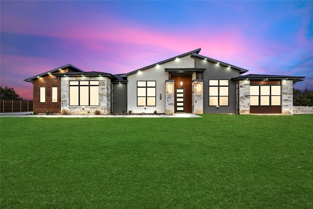 view of front of home with fence, a front lawn, and stucco siding