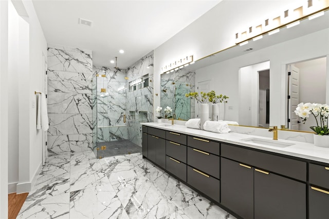 full bathroom with marble finish floor, a marble finish shower, double vanity, recessed lighting, and a sink