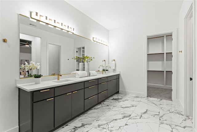 full bathroom with marble finish floor, double vanity, visible vents, a spacious closet, and a sink