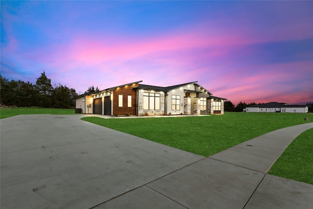 modern home featuring a front lawn, driveway, and an attached garage