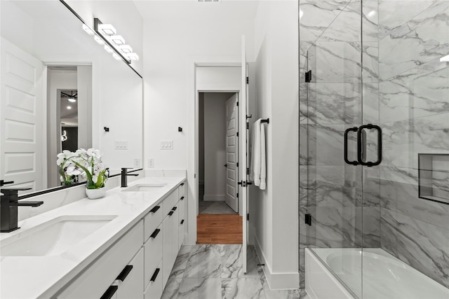 full bathroom with marble finish floor, combined bath / shower with glass door, a sink, and double vanity