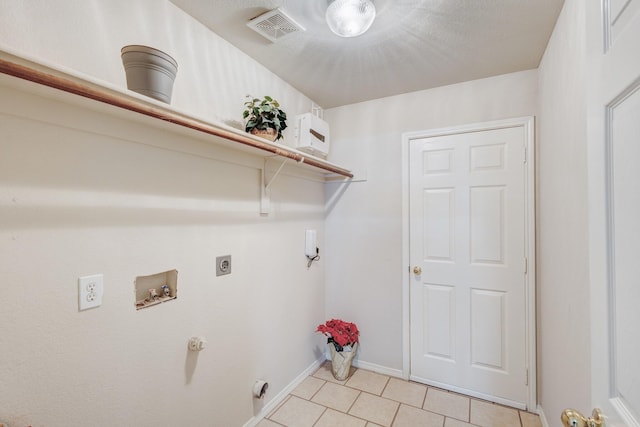 clothes washing area with washer hookup, light tile patterned floors, visible vents, electric dryer hookup, and laundry area