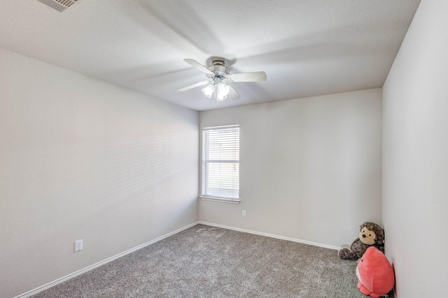 carpeted empty room featuring a textured ceiling, a ceiling fan, and baseboards