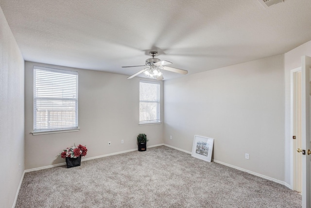 unfurnished room featuring carpet floors, baseboards, a ceiling fan, and a textured ceiling