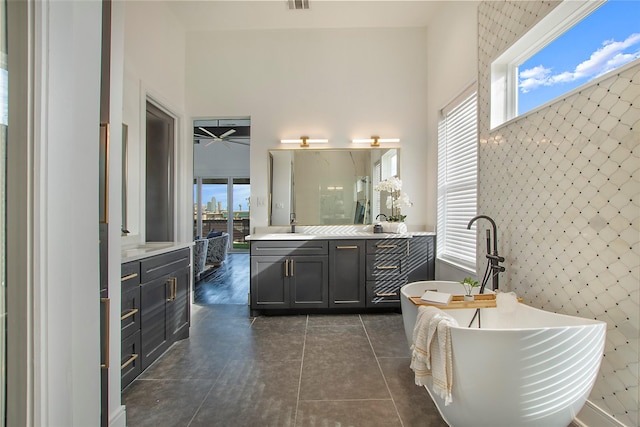 full bathroom featuring vanity, a soaking tub, tile patterned flooring, and visible vents