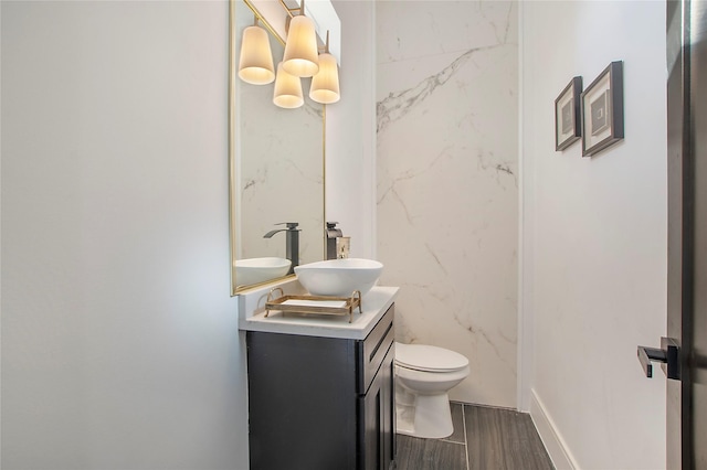 bathroom featuring toilet, vanity, and wood tiled floor