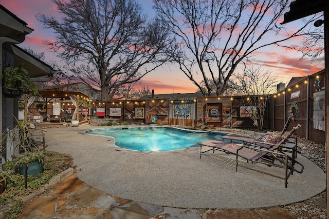 pool with a patio area and fence