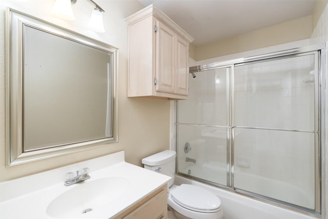 bathroom with toilet, enclosed tub / shower combo, and vanity