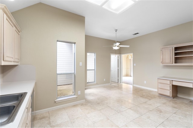 kitchen featuring lofted ceiling, light countertops, built in study area, ceiling fan, and a sink