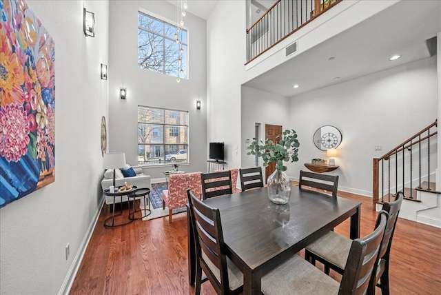 709 E 1st St, Fort Worth, TX 76102 - dining space with stairway, a high ceiling, wood finished floors, and baseboards