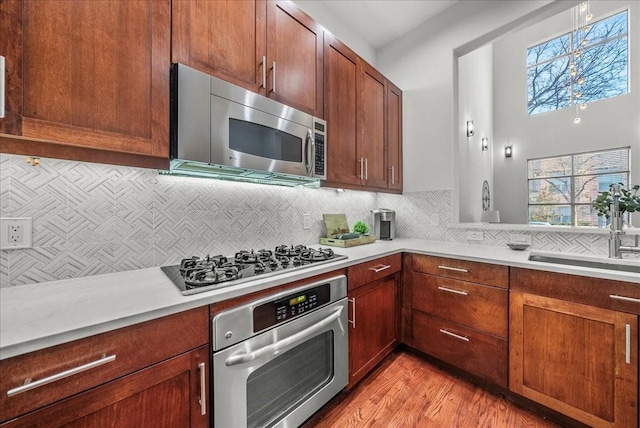709 E 1st St, Fort Worth, TX 76102 - kitchen with appliances with stainless steel finishes, a sink, light countertops, and decorative backsplash