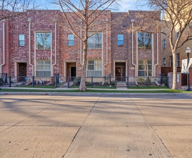 709 E 1st St, Fort Worth, TX 76102 - view of front facade with a fenced front yard and brick siding