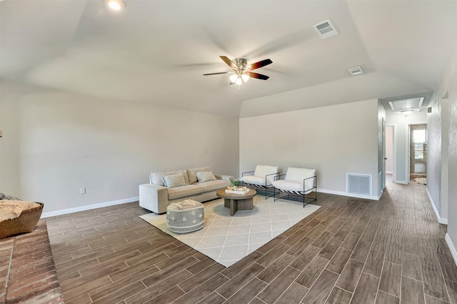 living area with attic access, visible vents, and wood finish floors