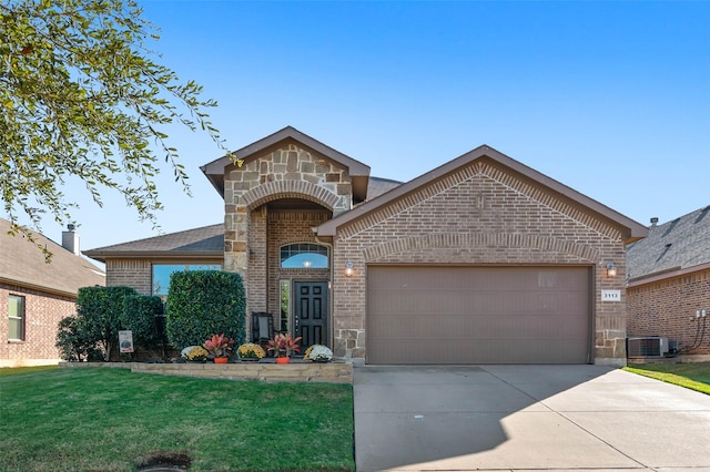 view of front of home with driveway, a garage, stone siding, a front lawn, and brick siding