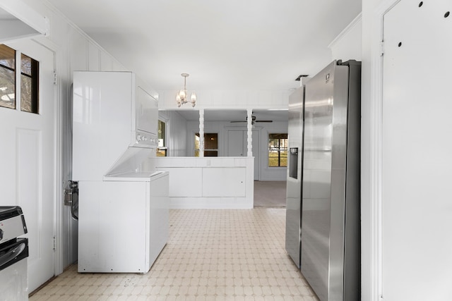 kitchen with light floors, light countertops, stacked washer / dryer, white cabinets, and stainless steel fridge with ice dispenser