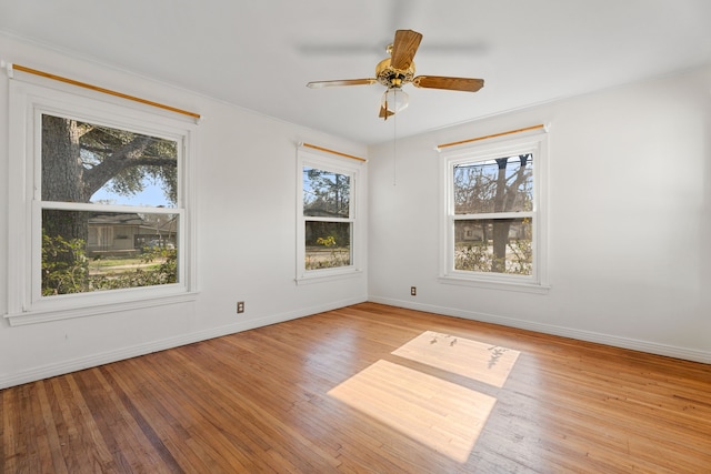 empty room with a healthy amount of sunlight, light wood-style floors, and baseboards