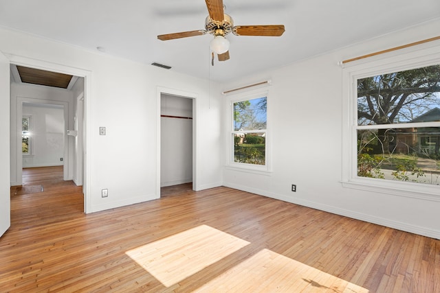 unfurnished bedroom with light wood finished floors, baseboards, visible vents, a ceiling fan, and a closet