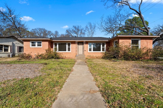 ranch-style house featuring brick siding and a front yard