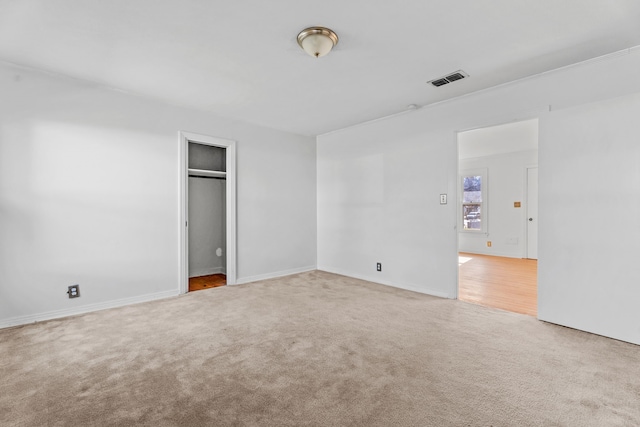 unfurnished bedroom with carpet floors, visible vents, and baseboards