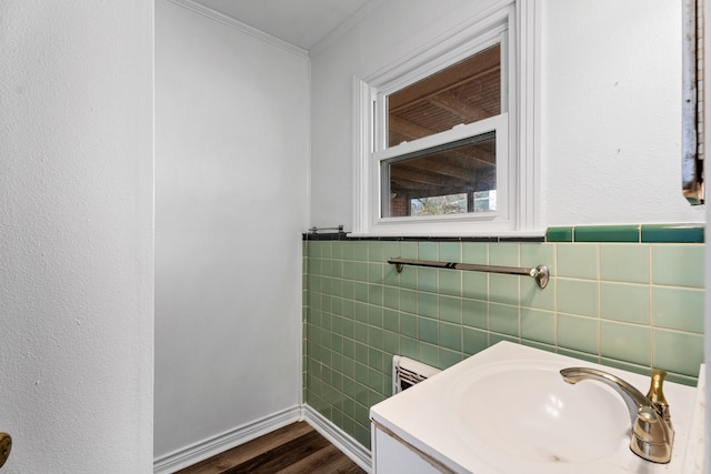 bathroom with ornamental molding, tile walls, vanity, and wood finished floors