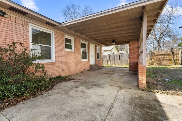 view of patio / terrace featuring entry steps, driveway, an attached carport, and fence