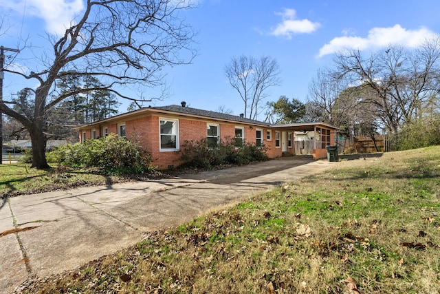 view of front of home with driveway, brick siding, and a front yard