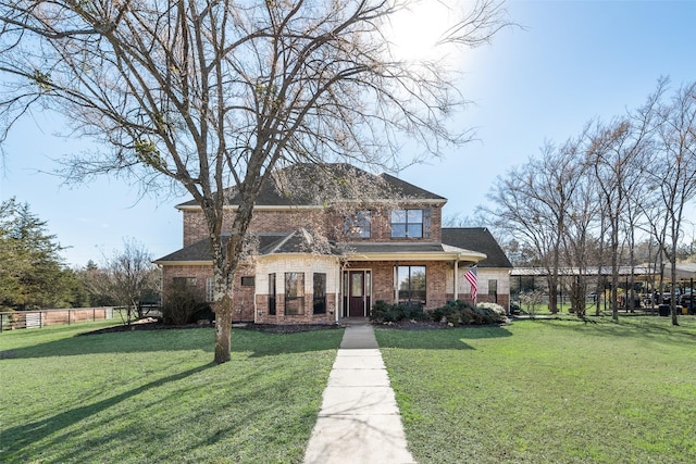 view of front facade featuring brick siding, fence, and a front lawn