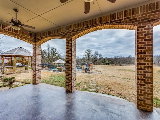 view of patio / terrace featuring ceiling fan, a gazebo, and a pool