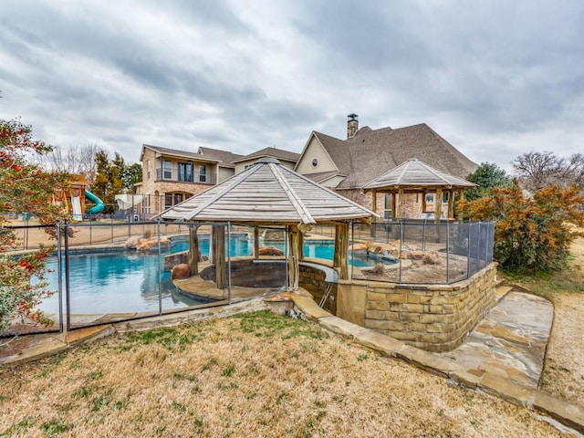 view of swimming pool with a gazebo, a water slide, and a fenced in pool