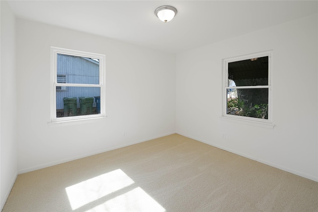 spare room featuring carpet floors and baseboards