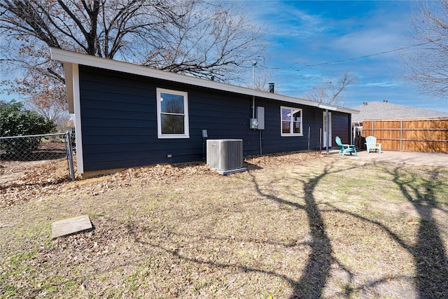 rear view of house with a patio area, fence, and cooling unit