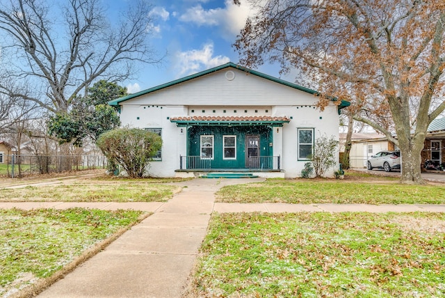 bungalow with a porch, a front yard, and fence