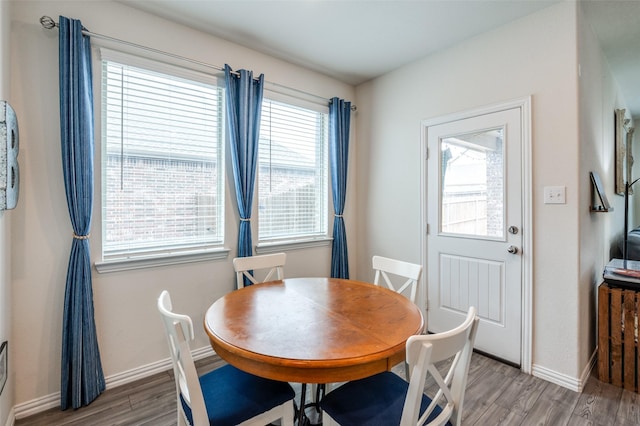 dining room featuring plenty of natural light, wood finished floors, and baseboards