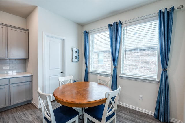 dining space with dark wood-type flooring and baseboards