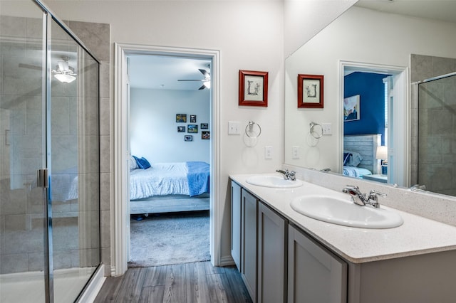 ensuite bathroom with a sink, ceiling fan, connected bathroom, and wood finished floors