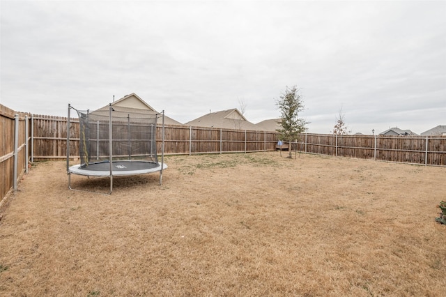 view of yard featuring a fenced backyard and a trampoline