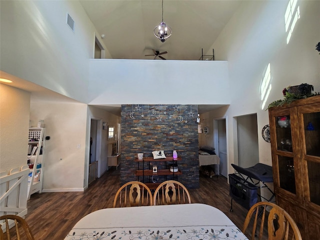 dining room with a ceiling fan, a high ceiling, visible vents, and dark wood-style flooring