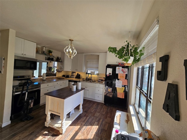 kitchen featuring dark countertops, appliances with stainless steel finishes, dark wood-style flooring, white cabinetry, and a sink